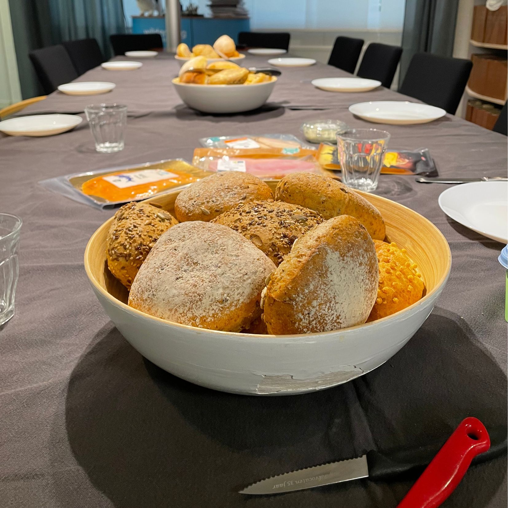 Een grote schaal met luxe biologische en ambachtelijke broodjes op een gedekte tafel voor een gecaterde lunch